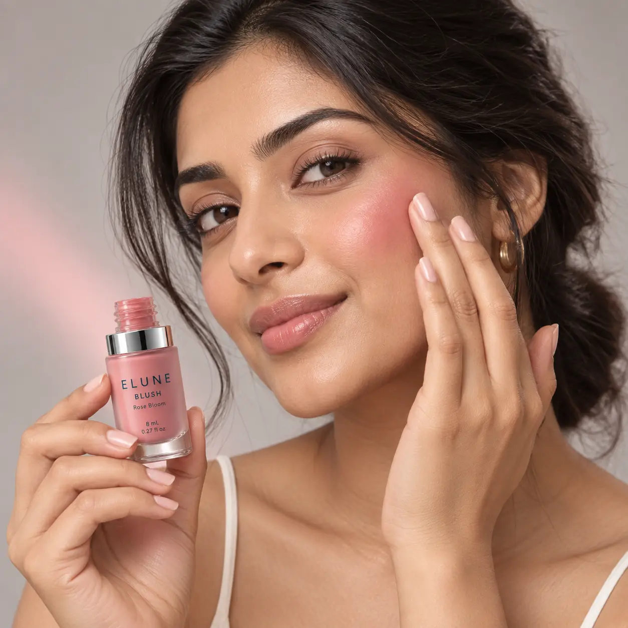 Woman blending ELUNE Rose Bloom Blush onto her cheek