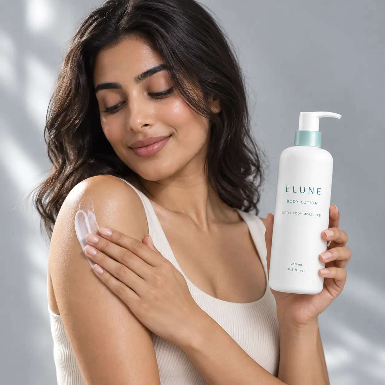 Woman smoothing ELUNE Body Lotion onto her shoulder