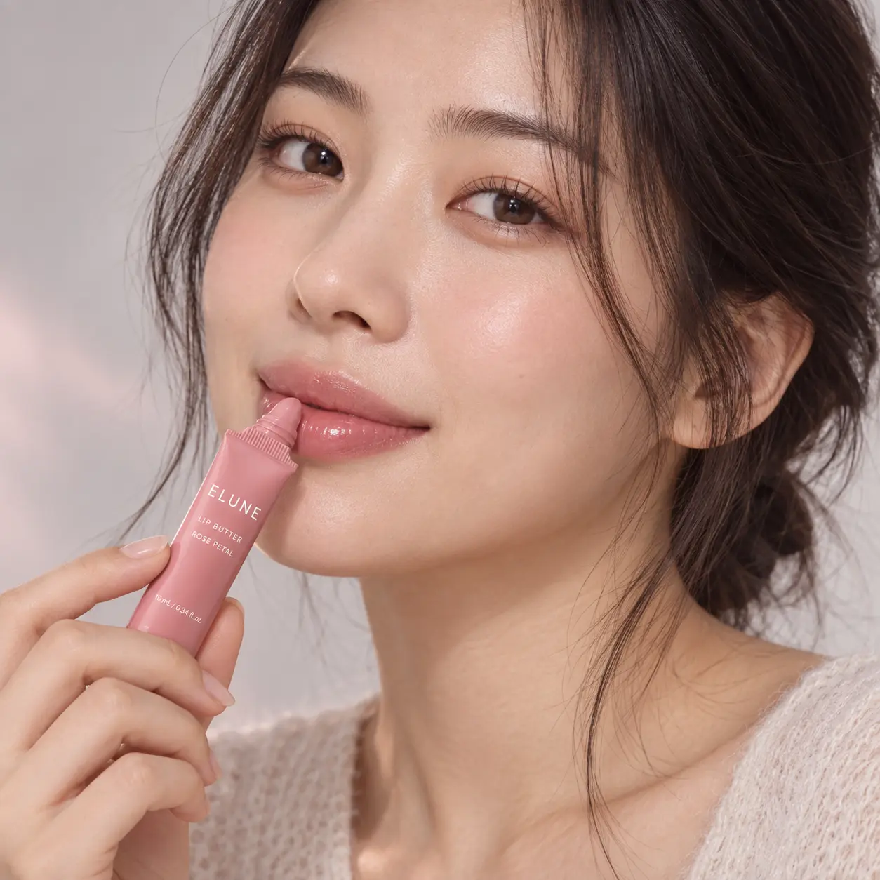 Woman applying ELUNE Rose Petal Lip Butter