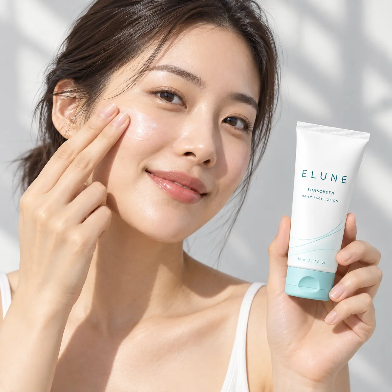 Woman applying ELUNE Sunscreen to her cheek